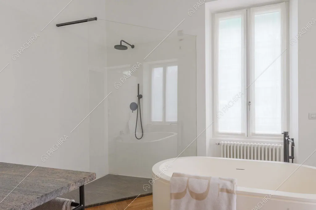 Ampio box doccia e vasca nel bagno con pavimento in parquet e pareti bianche