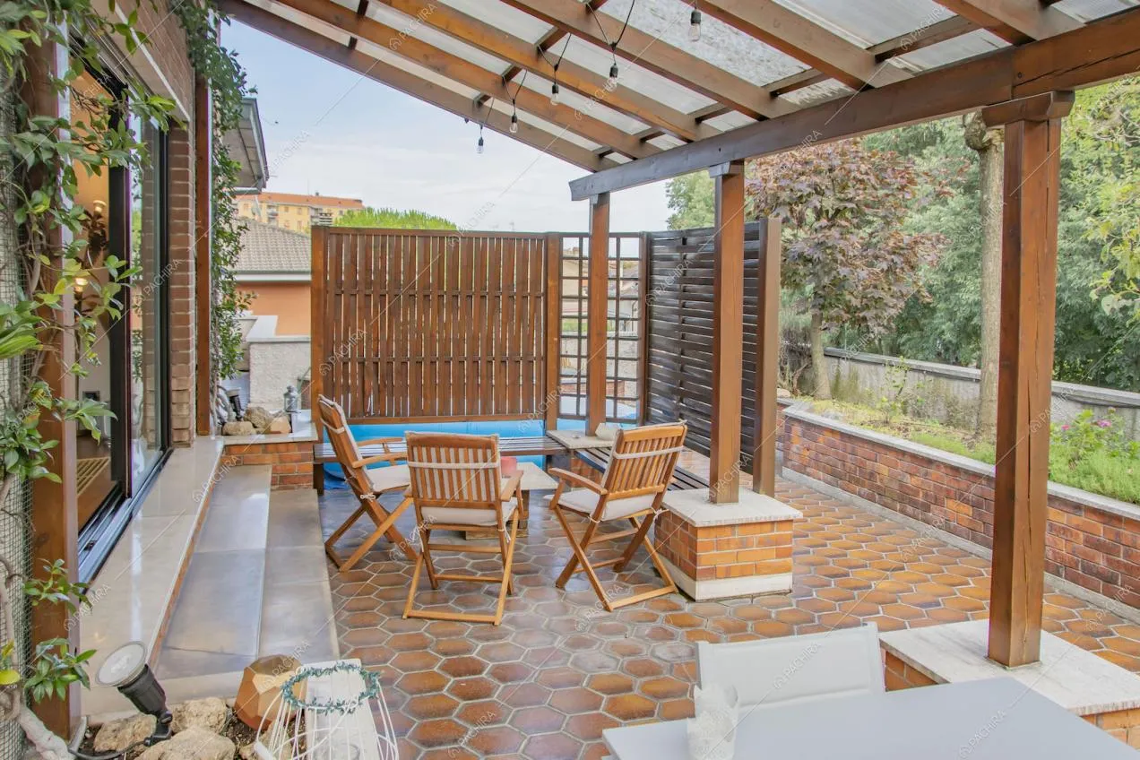 Veranda sulla terrazza con cementine e tavolo da pranzo in legno
