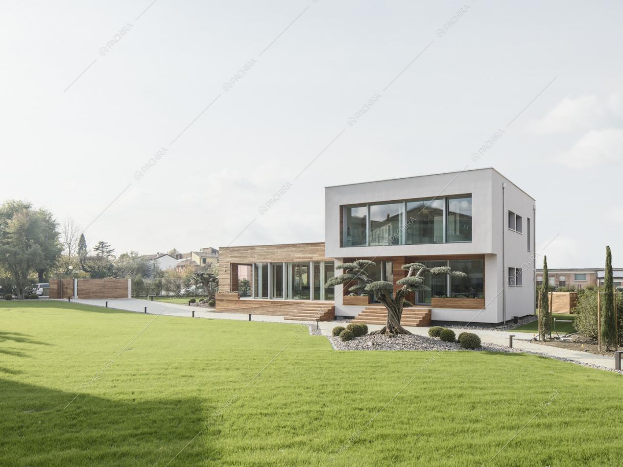 Giardino privato della Location Zucchina con vista sulla villa, le cui due strutture che la compongono riflettono l'alternarsi di vetro e legno degli interni