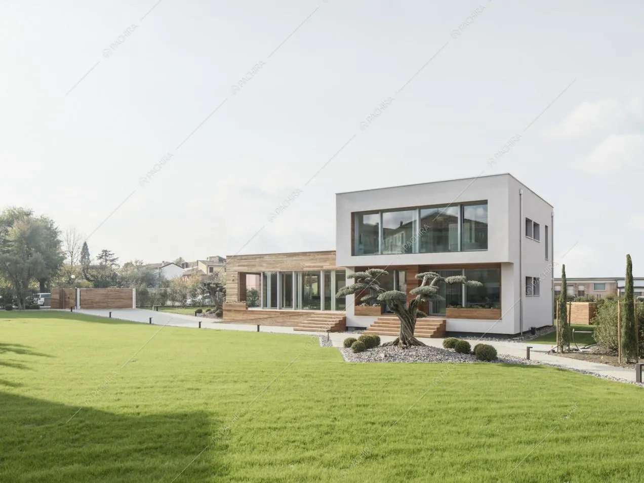 Giardino privato della Location Zucchina con vista sulla villa, le cui due strutture che la compongono riflettono l'alternarsi di vetro e legno degli interni