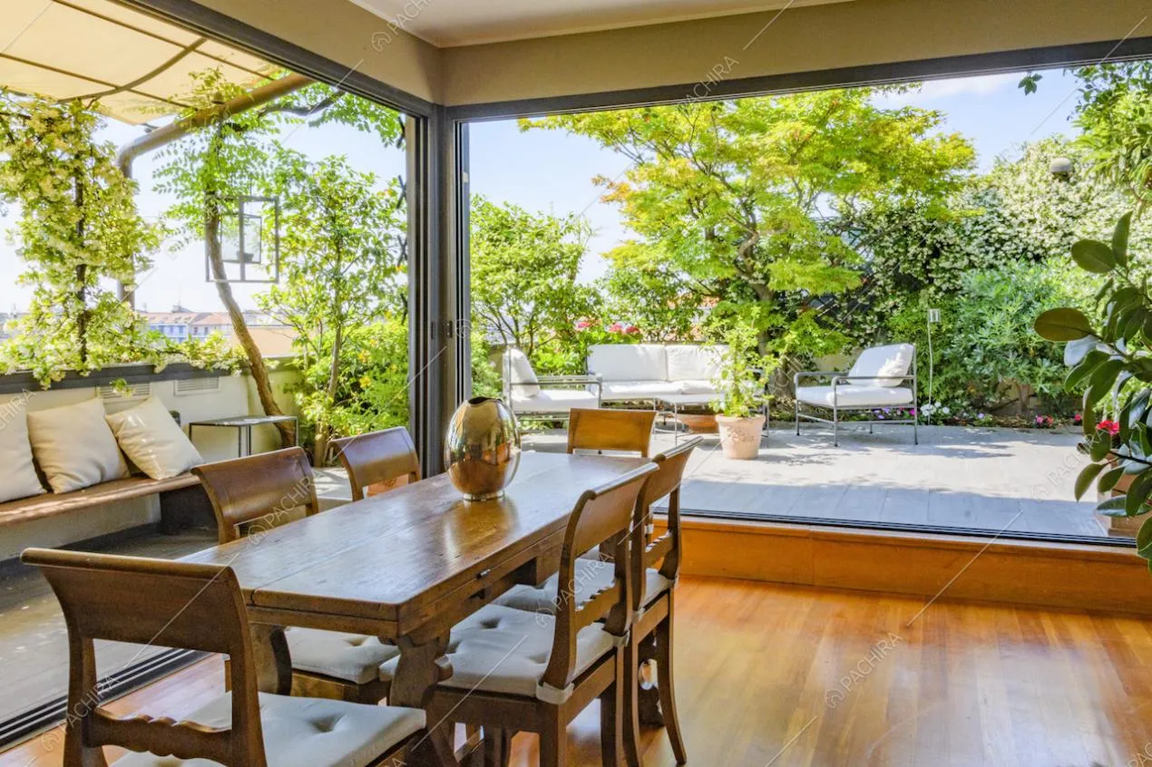 Tavolo da pranzo circondato da vetrate con vista sul terrazzo
