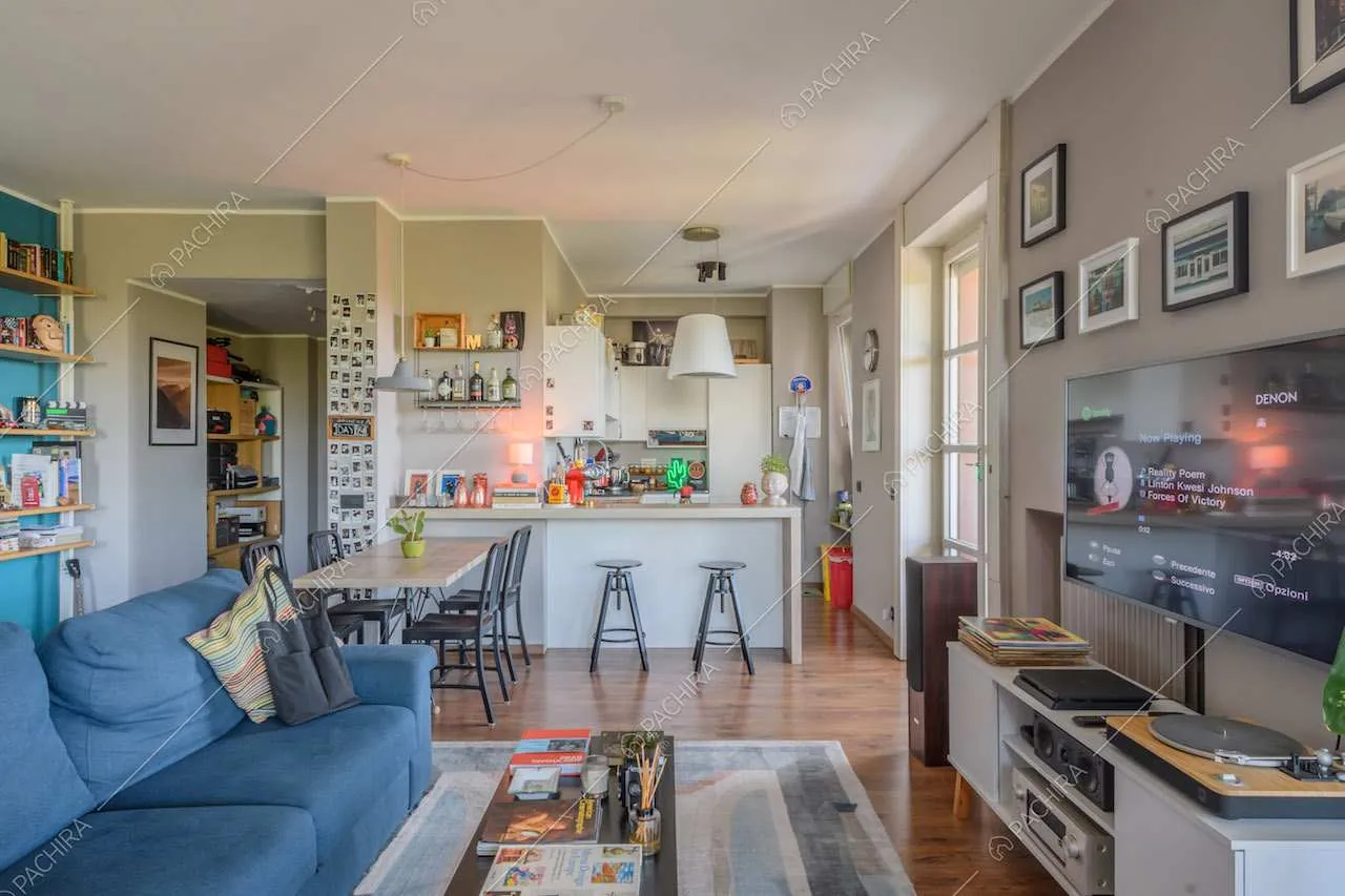 Sala con divano blu, pavimento in parquet e pareti grigie