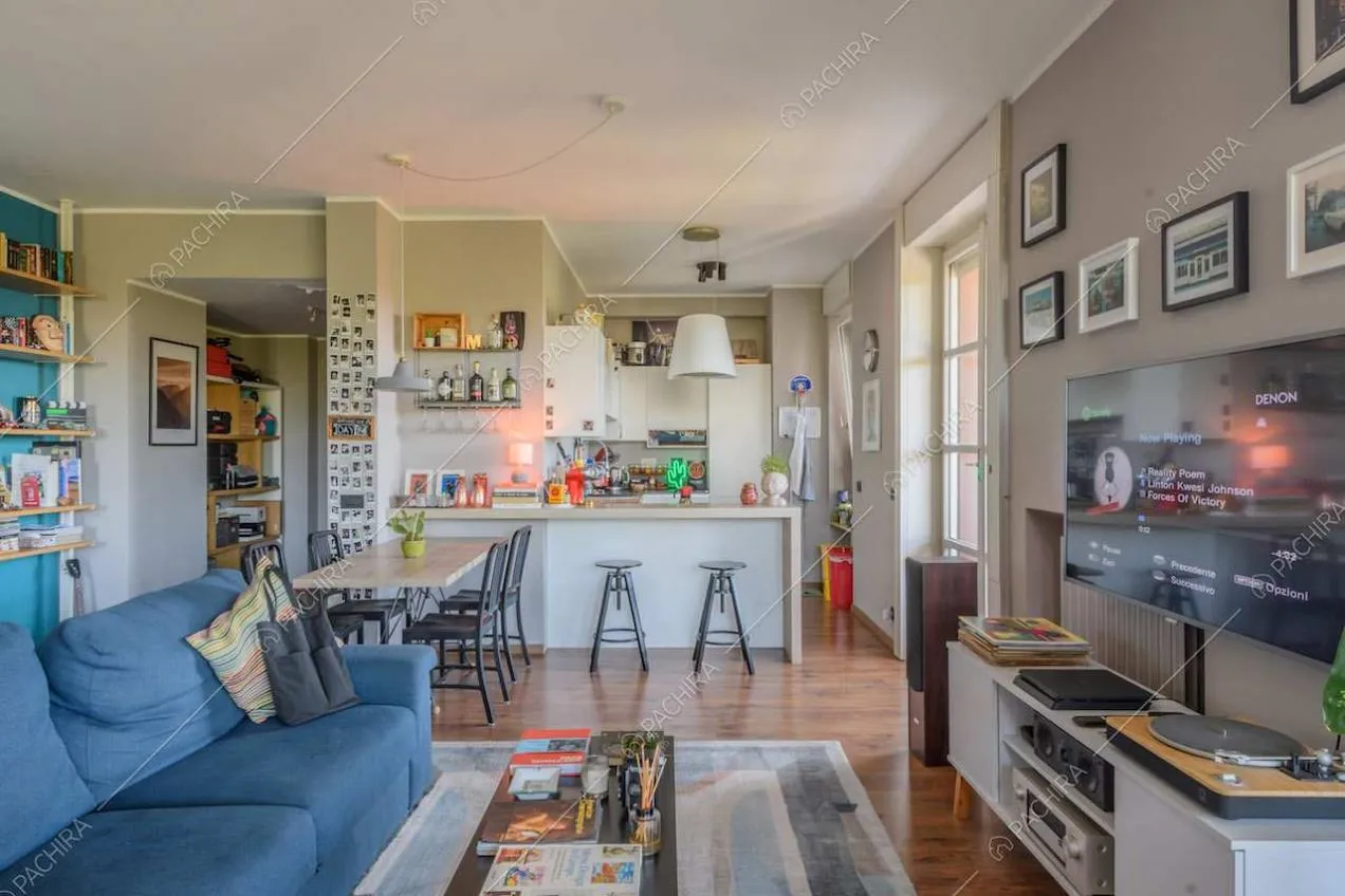 Sala con divano blu, pavimento in parquet e pareti grigie