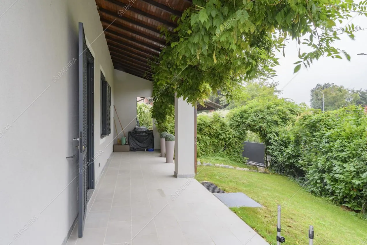 Angolo di giardino con siepi e portico su un lato della villa