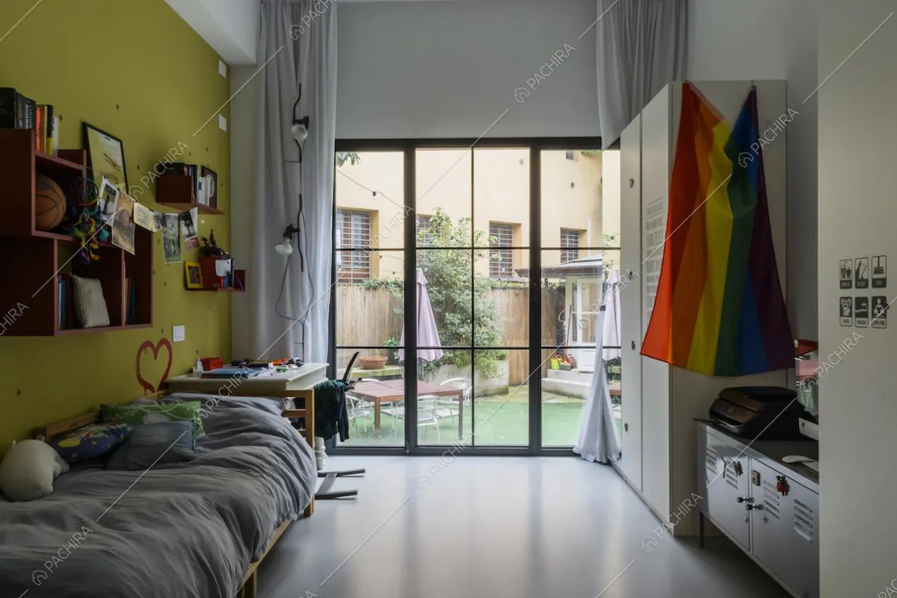 Camera da letto con parete color senape e vista sul giardino