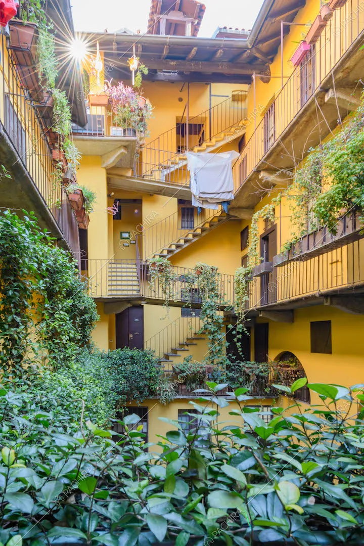 Cortile interno color giallo Milano tipico delle case di ringhiera