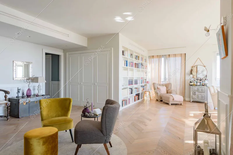 Ampia sala con armadio a parete con boiserie e pavimento in parquet a spina di pesce