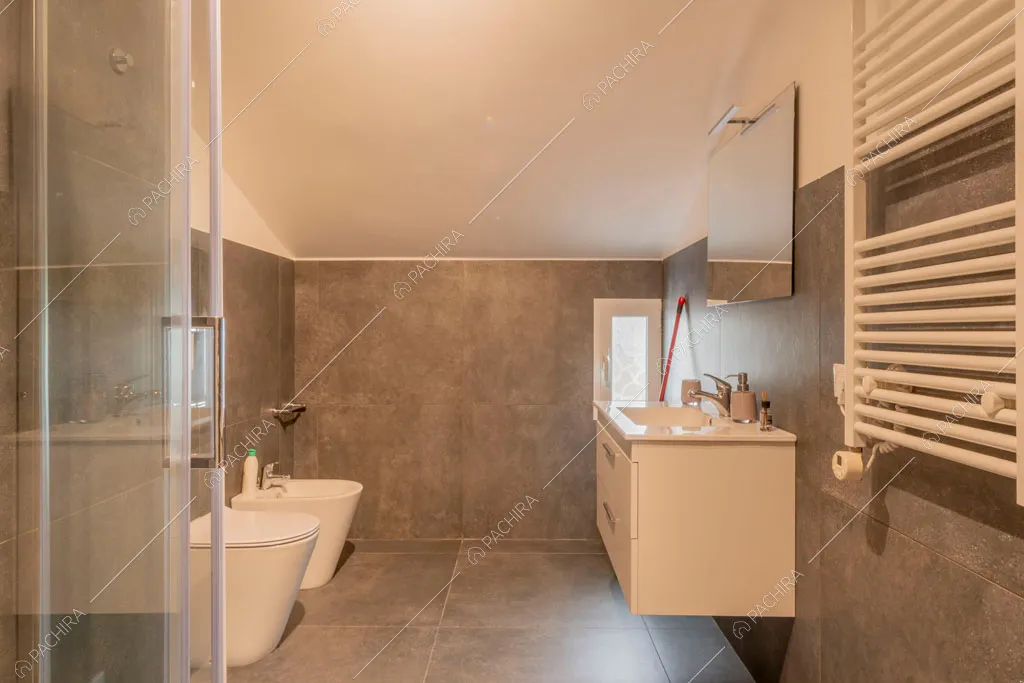 Bagno con box doccia e piastrelle grigie su pavimento e pareti della villa Murray, location in stile contemporaneo a Roma