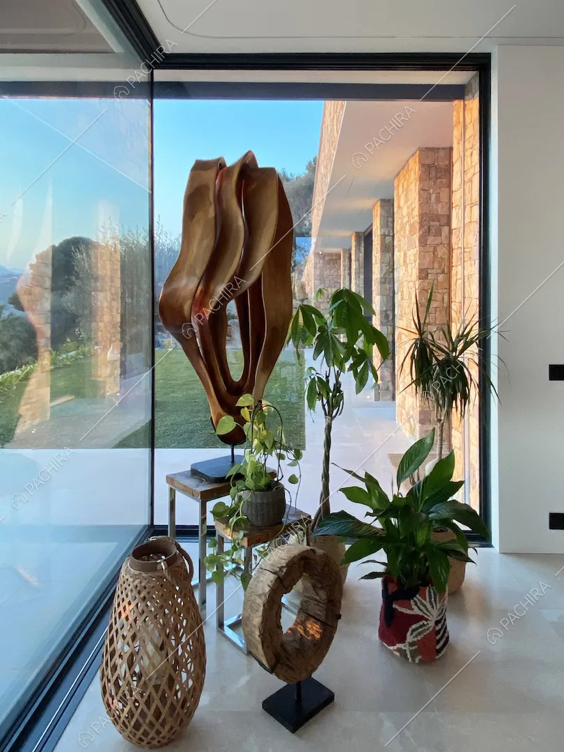 Piante e sculture di design nella zona living con vetrate e vista sulal terrazza
