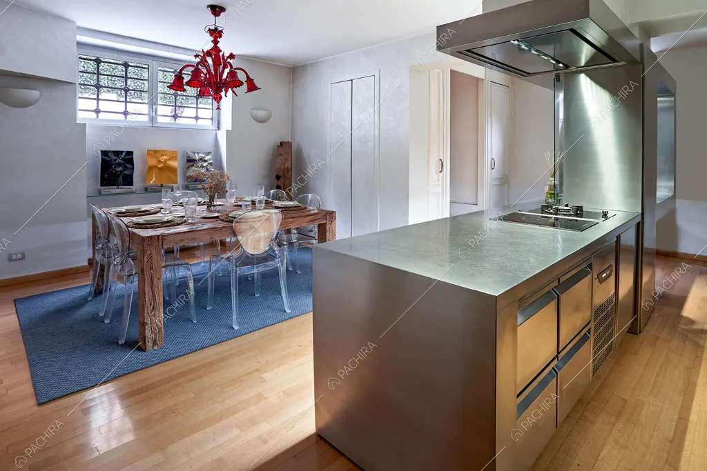Cucina in acciaio a penisola della dimora storica Cerimoya, location in stile liberty a Milano
