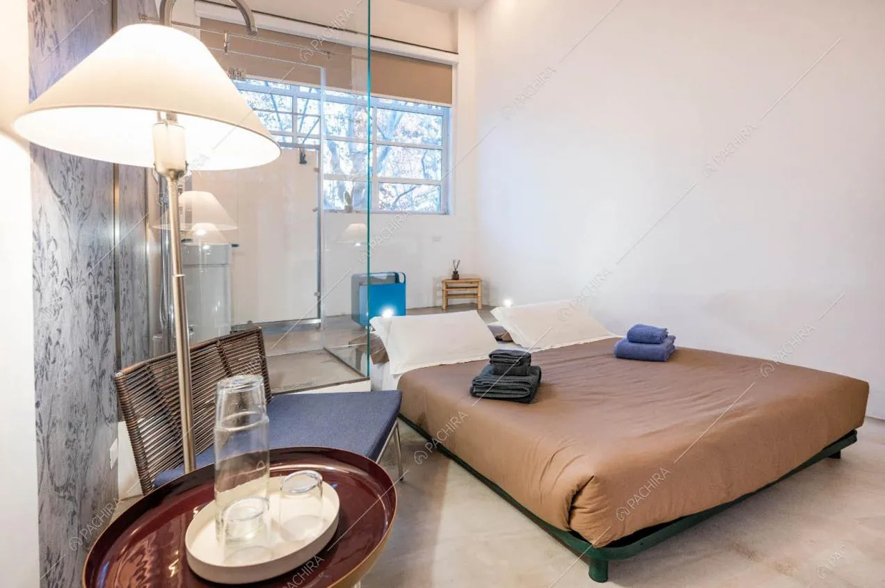 Camera da letto matrimoniale con box doccia, carta da parati e pavimento in resina