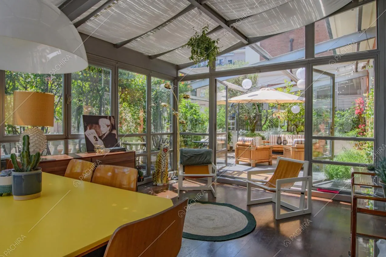 Grande veranda con tavolo da pranzo giallo sulla terrazza con ombrellone