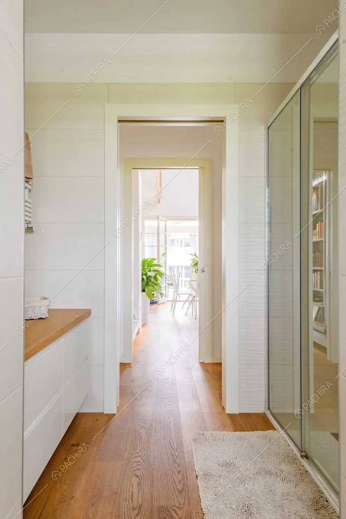 Dal bagno con pavimento in parquet e box doccia vista sulla zona living