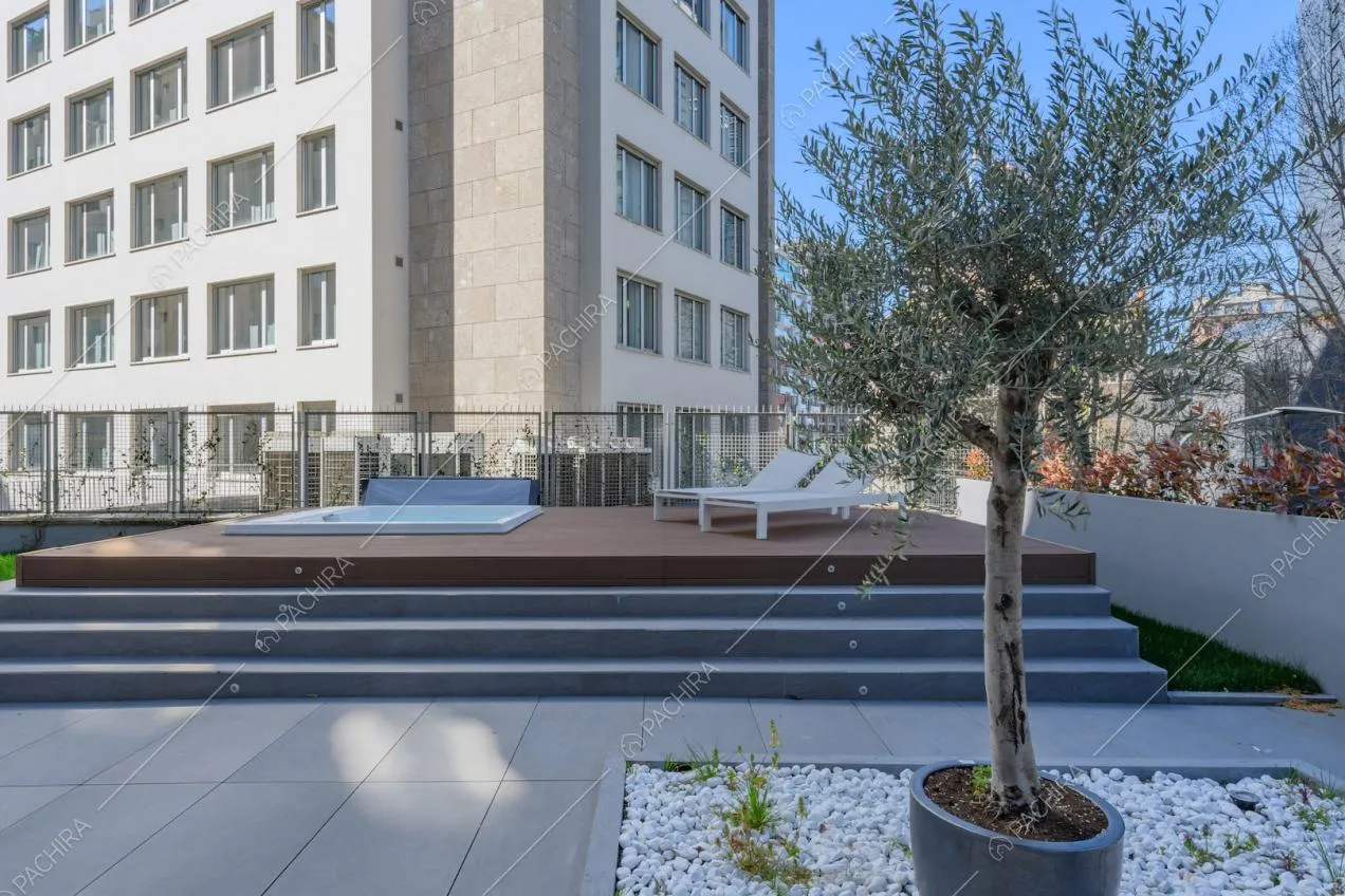 Olivo sulla terrazza con vasca idromassaggio e vista sugli edifici circostanti