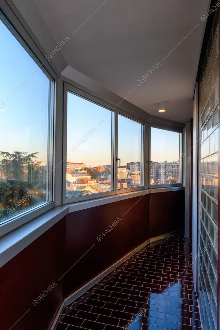 Corridoio con pavimento e pareti in piastrelle rosse lucide e vista sullo skyline milanese